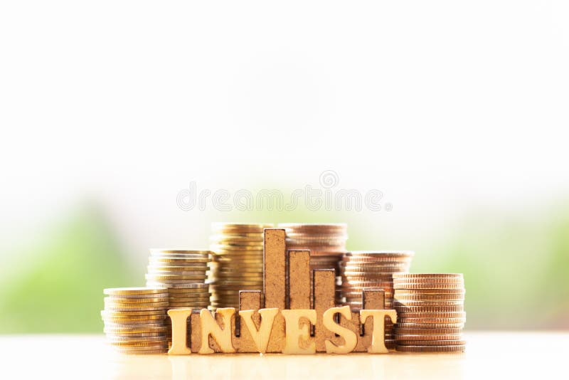 Inventa o empilhamento e os blocos de madeira com o texto INVESTEM no fundo da natureza das hortali?as imagem de stock Inventa o empilhamento e os blocos de madeira com o texto INVESTEM no fundo da natureza das hortali?as imagem de stock