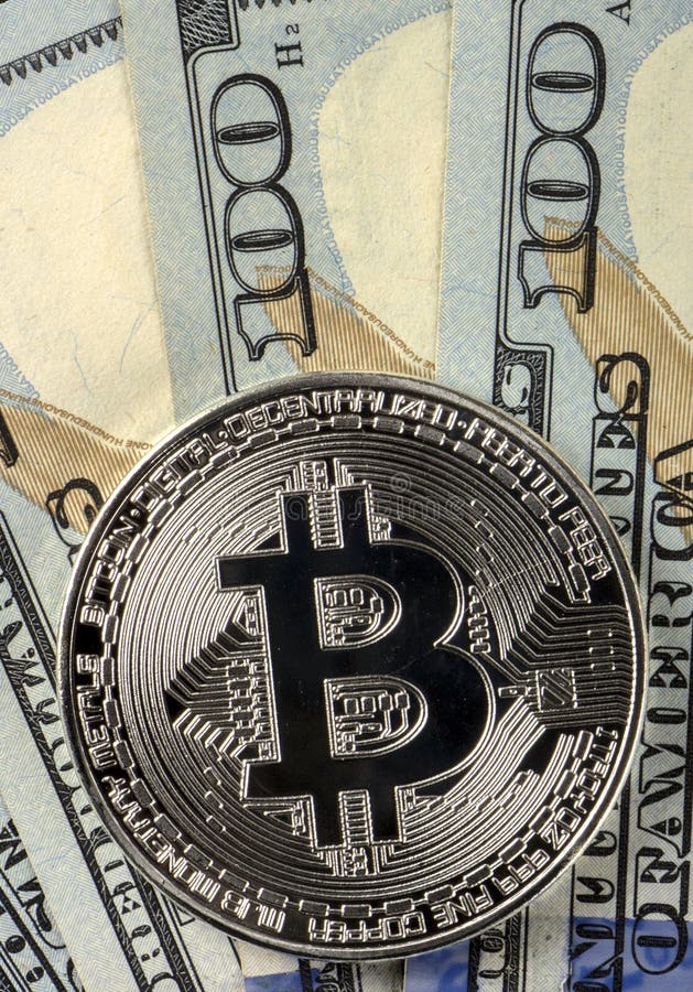 Invente le bitcoin sur un fond de 100 dollars américains de plans rapprochés photos stock Invente le bitcoin sur un fond de 100 dollars américains de plans rapprochés photos stock