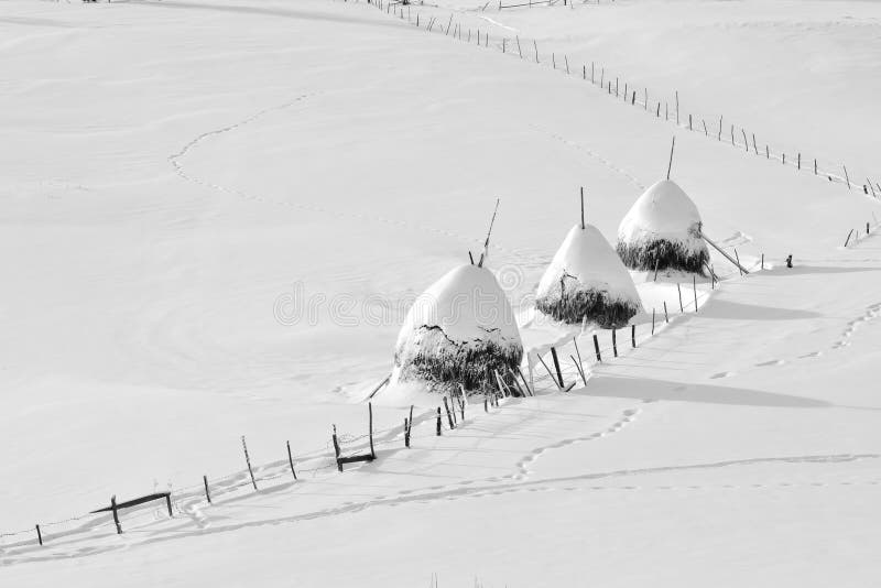 Inverno in Romania, mucchio di fieno nel villaggio della Transilvania immagine stock libera da diritti Inverno in Romania, mucchio di fieno nel villaggio della Transilvania immagine stock libera da diritti