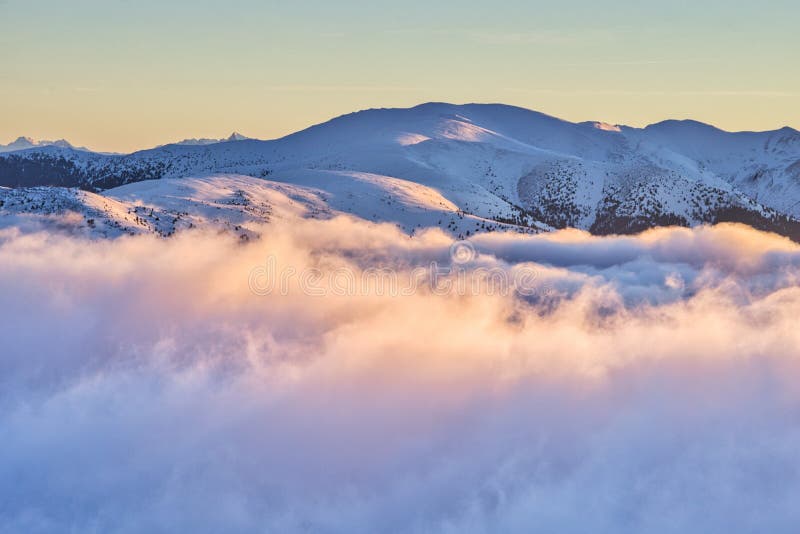 Inverzní mraky v Nízkých Tatrách během zimního východu slunce