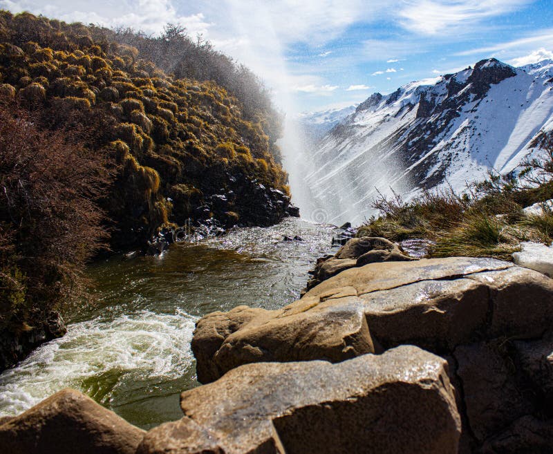 Waterfall in the middle of the snowy mountains where the water goes in the opposite direction due to the force of the wind royalty free stock images