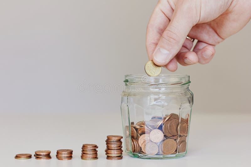 Investerend, besparend geld of kwekend bedrijfsconcept Mannelijke hand die geldmuntstuk in de glaskruik zetten stock foto's Investerend, besparend geld of kwekend bedrijfsconcept Mannelijke hand die geldmuntstuk in de glaskruik zetten stock foto's