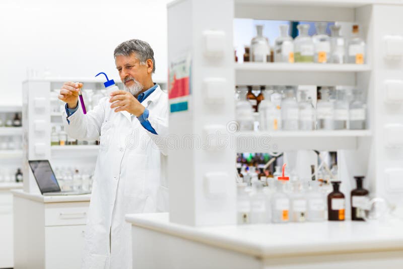 Investigación científica de realización del investigador de sexo masculino mayor en un laboratorio imagen de archivo Investigación científica de realización del investigador de sexo masculino mayor en un laboratorio imagen de archivo