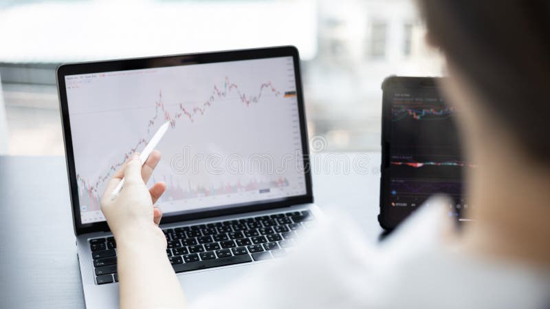 Investors sit and watch graphs of stock market data and watch the world market chart change