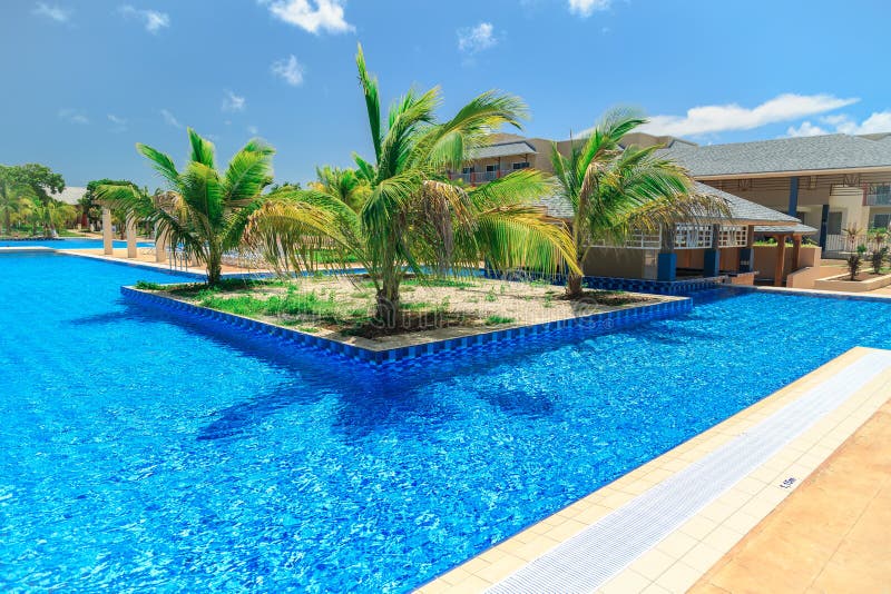 Inviting gorgeous view of swimming pool, tranquil turquoise azure water and tropical garden