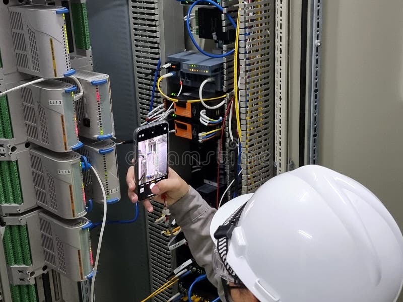 The Engineer takes a photo Interface module of the DCS control system panel. The Engineer takes a photo Interface module of the DCS control system panel