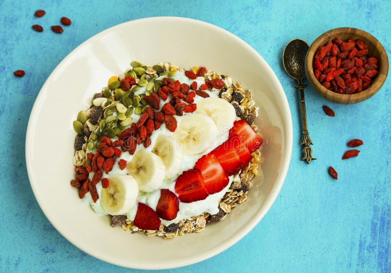 Iogurte com muesli, bagas do goji, banana e morangos foto de stock Iogurte com muesli, bagas do goji, banana e morangos foto de stock