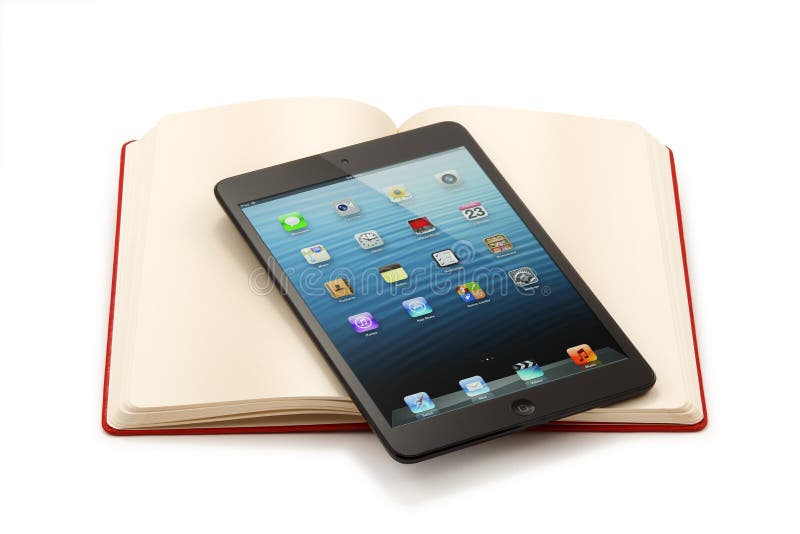 Ipad Mini auf offenem Buch - Beschneidungspfad stockbild Ipad Mini auf offenem Buch - Beschneidungspfad stockbild