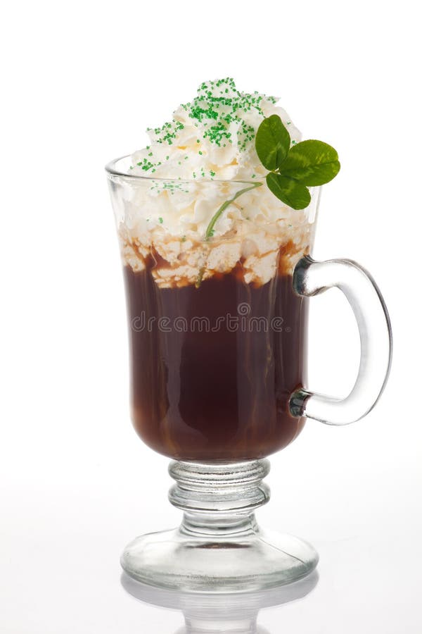 Mug of Irish Coffee with green sprinkles and clover leaf for St Patrick's Day