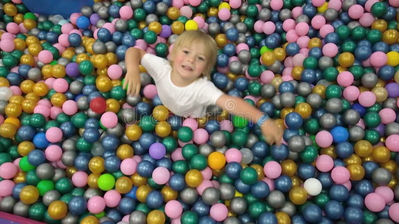 irmão com irmã jogando na piscina de bolinhas coloridas. playground interno  de creche. piscina de bolinhas para crianças. sala de jogos do jardim de  infância ou pré-escola. 5848214 Foto de stock no