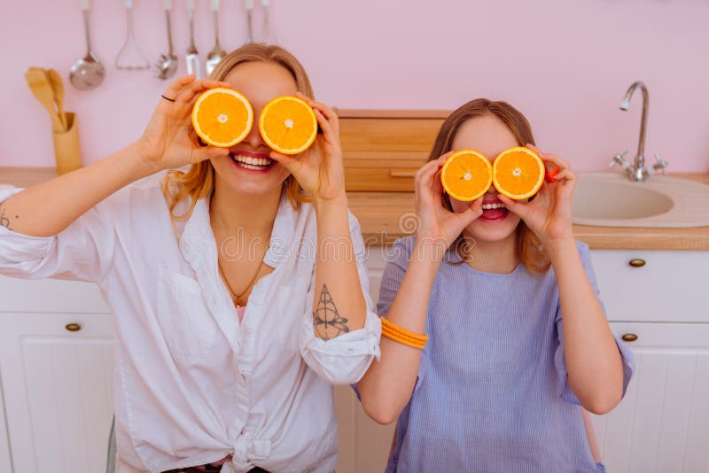 Irmã mais idosa com tatuagem em sua mão que guarda laranjas com seu irmão fotografia de stock Irmã mais idosa com tatuagem em sua mão que guarda laranjas com seu irmão fotografia de stock