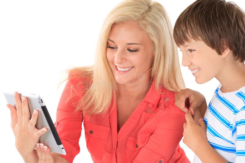 Happy sister in pink blouse showing electronic tablet or e-book to brother wearing blue striped t-shirt on white background. Happy sister in pink blouse showing electronic tablet or e-book to brother wearing blue striped t-shirt on white background.