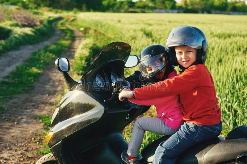Irmão e irmã que jogam em uma motocicleta imagem de stock royalty free Irmão e irmã que jogam em uma motocicleta imagem de stock royalty free