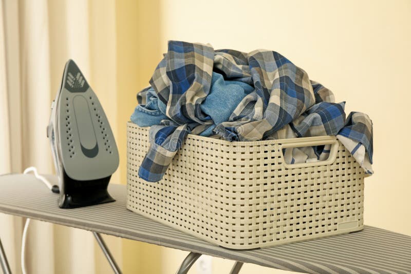 Iron and Basket with Clothes on Ironing Board Isolated Stock Photo