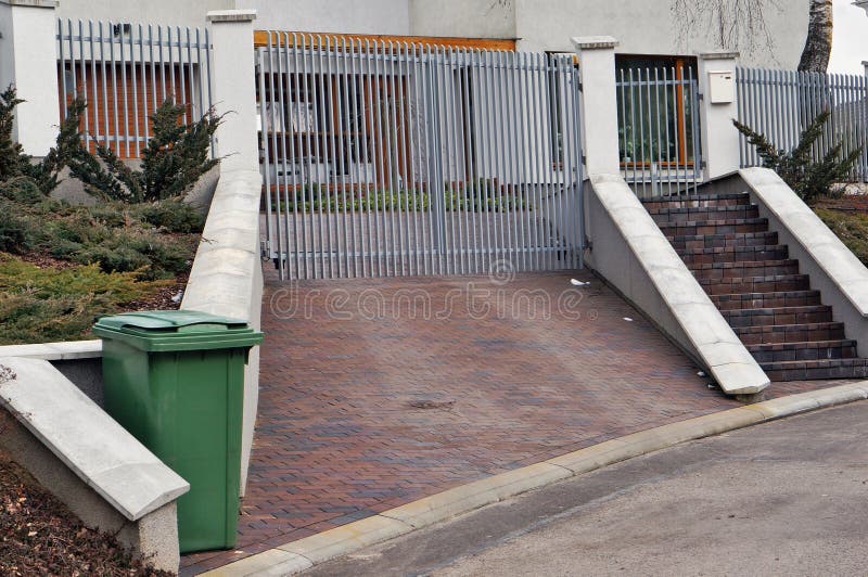 Iron gate and green trash stock photo