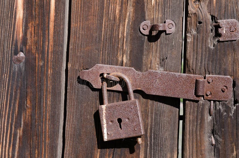 The New Iron Lock on an Old Metal Fixing Hangs on a High Wooden Gate ...