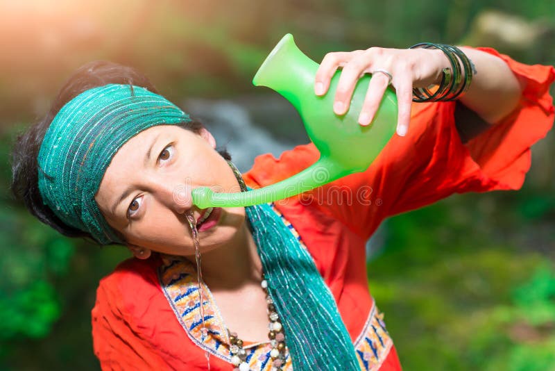 Jala neti nasal irrigation with a woman in nature in spring. Jala neti nasal irrigation with a woman in nature in spring