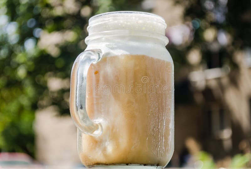 Iskallt bryggat kaffe och mjölkar fradga som tjänas som i murarekrus royaltyfria foton Iskallt bryggat kaffe och mjölkar fradga som tjänas som i murarekrus royaltyfria foton