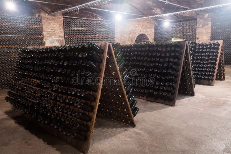Iskrzastego wina butelki fermentuje w wytwórnia win lochu zdjęcie stock Iskrzastego wina butelki fermentuje w wytwórnia win lochu zdjęcie stock