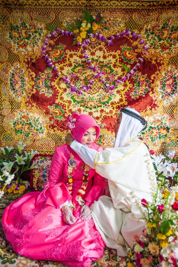 Islamische Hochzeit, Bräutigam, der eine Goldhalskette auf Braut setzt Traditi lizenzfreies stockfoto Islamische Hochzeit, Bräutigam, der eine Goldhalskette auf Braut setzt Traditi lizenzfreies stockfoto