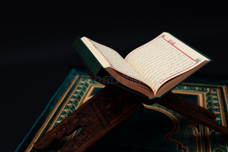 Islamski ?wi?ta ksi?ga koran na drewnianym cyzelowania rahle z r??an?w koralikami i modlitewny dywanik na czarnym tle Kuran ?wi?t zdjęcia royalty free Islamski ?wi?ta ksi?ga koran na drewnianym cyzelowania rahle z r??an?w koralikami i modlitewny dywanik na czarnym tle Kuran ?wi?t zdjęcia royalty free