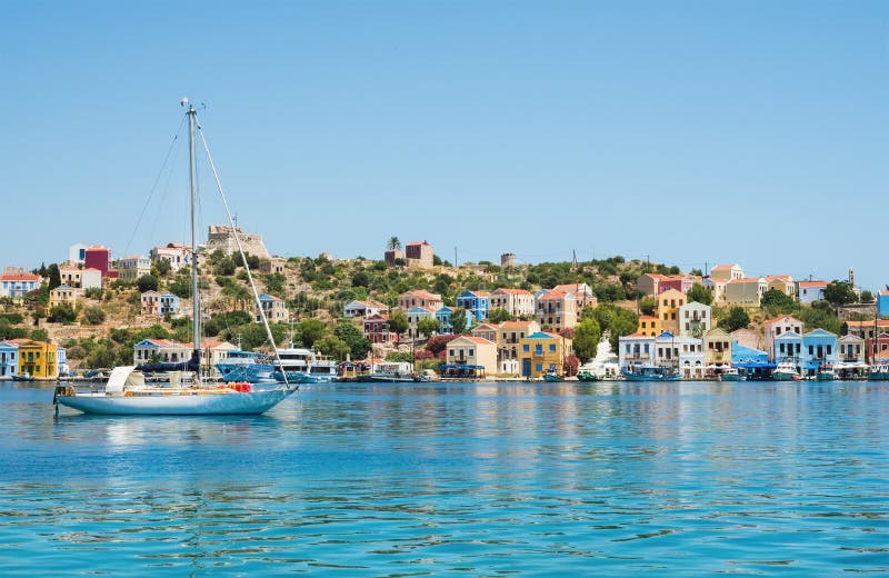 Island coast with colorful houses, clear sea water, yacht, Greece