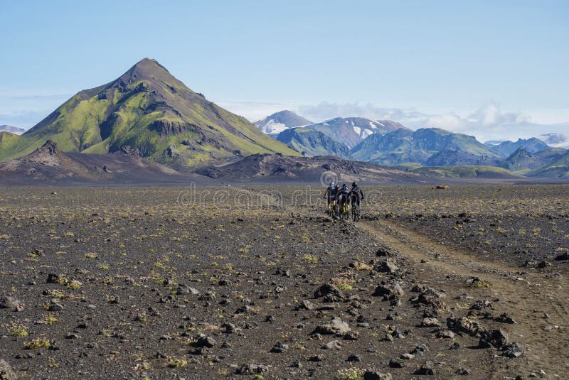 Isländische Lavawüstenlandschaft mit Gruppe von Bikern auf Laugavegur Wanderweg mit Blick auf Tindfjallajokull Gletscher lizenzfreie stockbilder Isländische Lavawüstenlandschaft mit Gruppe von Bikern auf Laugavegur Wanderweg mit Blick auf Tindfjallajokull Gletscher lizenzfreie stockbilder