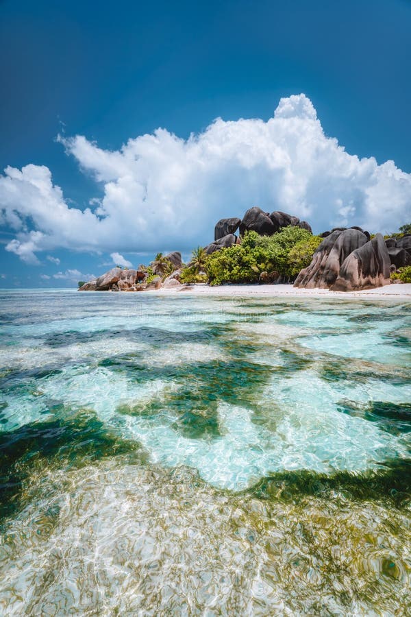 La Digue island, Seychelles. Famous paradise beach Anse Source d`Argent with shallow blue lagoon, granite boulders and white clouds. La Digue island, Seychelles. Famous paradise beach Anse Source d`Argent with shallow blue lagoon, granite boulders and white clouds.