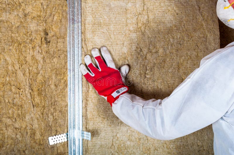Isolamento del sottotetto della soffitta a mano fotografia stock libera da diritti Isolamento del sottotetto della soffitta a mano fotografia stock libera da diritti
