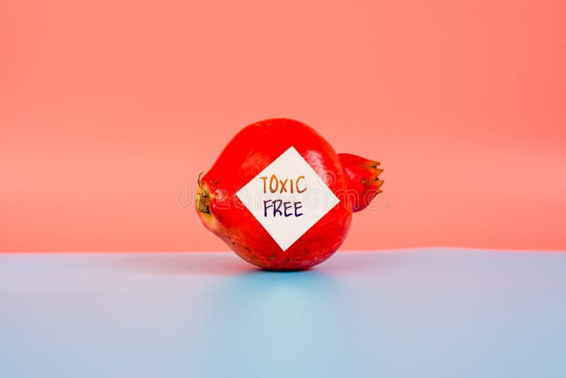 Isolated fruit on flat background labeled with genetically modified food warning sticker royalty free stock photo