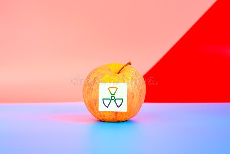 Isolated fruit on flat background labeled with genetically modified food warning sticker stock photo