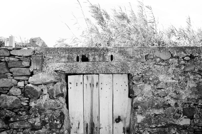 Isolated old wooden door in a stoned wall of a rural place Madeira, Portugal, Europe
