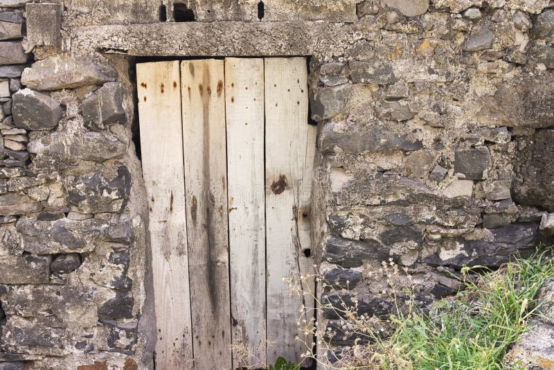 Isolated old wooden door in a stoned wall of a rural place Madeira, Portugal, Europe