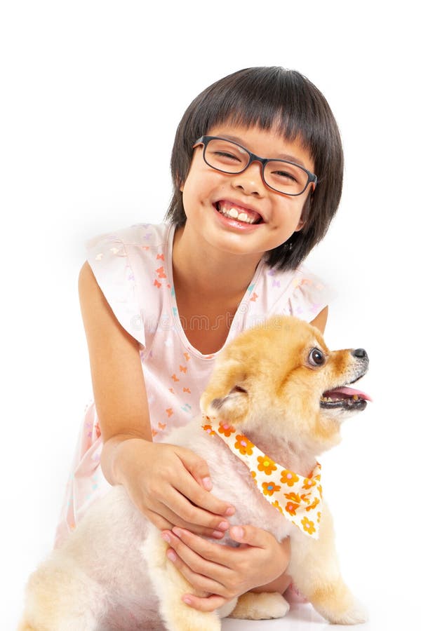 Isolated portrait Asian little girl holding Pomeranian dog with care on white background. Studio shot of girl and puppy royalty free stock photo Isolated portrait Asian little girl holding Pomeranian dog with care on white background. Studio shot of girl and puppy royalty free stock photo