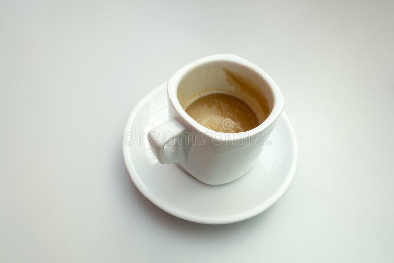 Isolated shot of a half full cup of coffee with milk  on white background