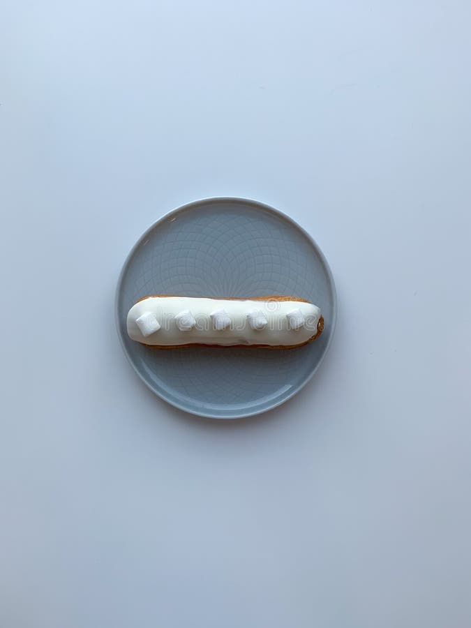 Isolated delicious white creme eclair with marshmallow on grey table. Dessert for breakfast and coffeetime. Top view. royalty free stock photo Isolated delicious white creme eclair with marshmallow on grey table. Dessert for breakfast and coffeetime. Top view. royalty free stock photo