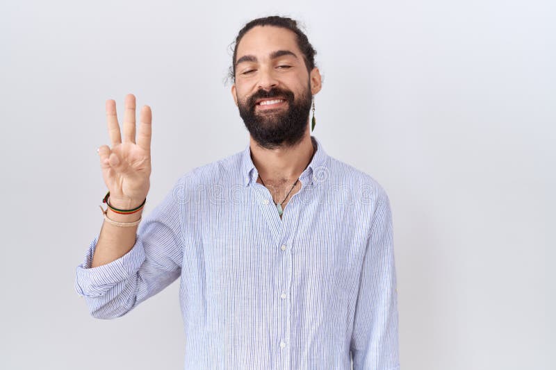 Ispanico con la barba che indossa una camicia casual che mostra e punta con le dita numero tre, sorridendo sicuro e felice