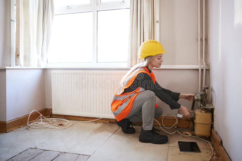 Ispettore femminile In Hard Hat ed alto rivestimento di visibilità che controlla l'approvvigionamento di gas immagini stock Ispettore femminile In Hard Hat ed alto rivestimento di visibilità che controlla l'approvvigionamento di gas immagini stock