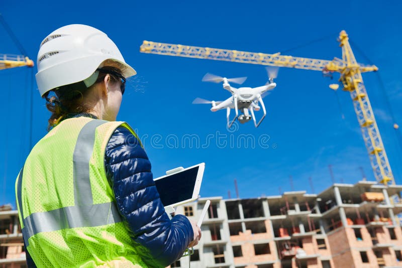 Ispezione del fuco Operatore che ispeziona volo del cantiere della costruzione con il fuco fotografia stock Ispezione del fuco Operatore che ispeziona volo del cantiere della costruzione con il fuco fotografia stock