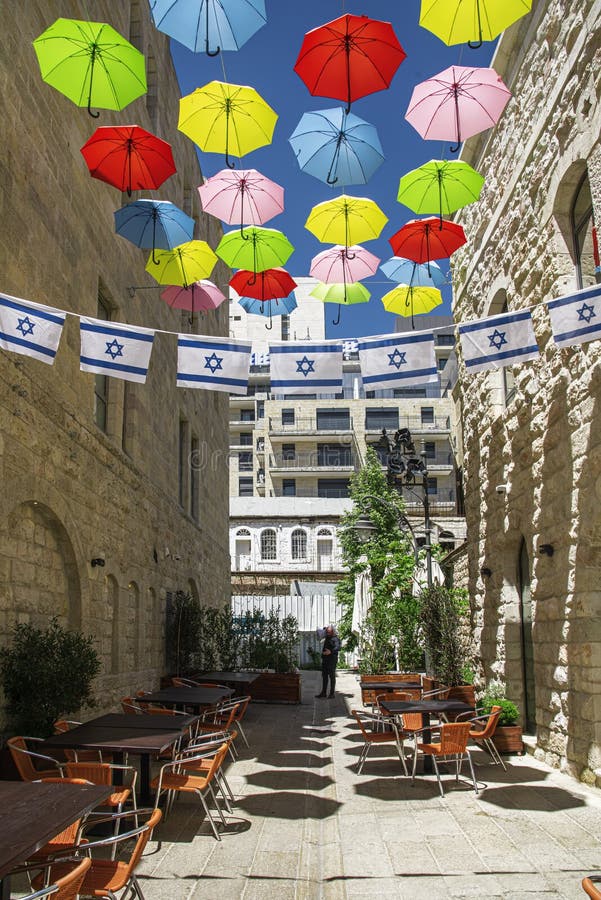 Israele-Gerusalemme 12-05-2019 Vista di una terrazza situata tra gli alti edifici, decorata con ombrelli e bandiere israeliane in immagini stock Israele-Gerusalemme 12-05-2019 Vista di una terrazza situata tra gli alti edifici, decorata con ombrelli e bandiere israeliane in immagini stock