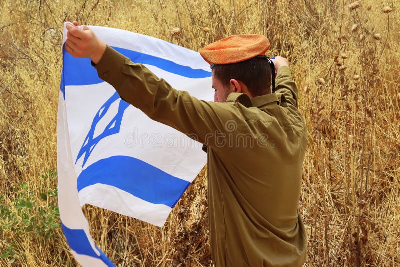 Soldier of the Israeli Army with a blurred Flag of Israel. Photo for Israel Independence Day, Memorial Day, Holocaust Remembrance Day. Israeli Soldier, IDF, patriotic photo. Soldier of the Israeli Army with a blurred Flag of Israel. Photo for Israel Independence Day, Memorial Day, Holocaust Remembrance Day. Israeli Soldier, IDF, patriotic photo.