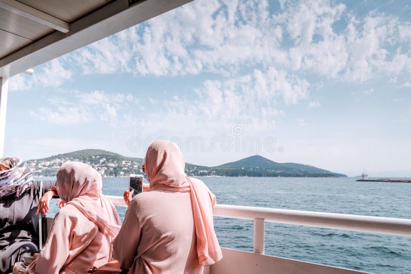 ISTAMBUL, TURQUIA - 29 de agosto de 2018: Mulheres em xailes cor-de-rosa na caminhada do mar foto de stock ISTAMBUL, TURQUIA - 29 de agosto de 2018: Mulheres em xailes cor-de-rosa na caminhada do mar foto de stock