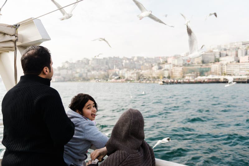 Istanbul, Turkey, December 1, 2014: Family on a ferry boat watching the seagulls flying around