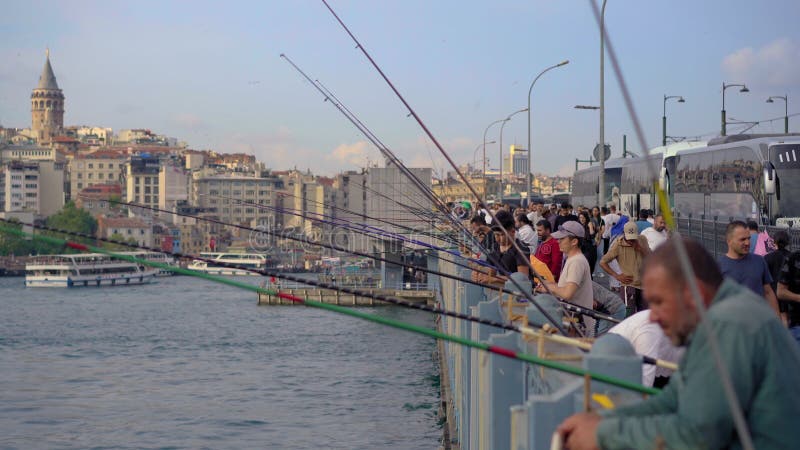 5052021 istanbul turkey : les pêcheurs bordent les mâts animés du pont de galata en main alors qu'ils cherchent leur prise