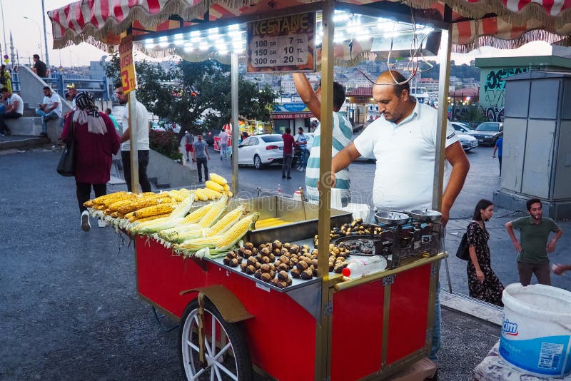 ISTANBUL, TURKIJE - 21 AUGUSTUS 2018: Straatverkoper van fast food met gekookte en gegrilde mais en kastanje op traditionele turk stock fotografie ISTANBUL, TURKIJE - 21 AUGUSTUS 2018: Straatverkoper van fast food met gekookte en gegrilde mais en kastanje op traditionele turk stock fotografie