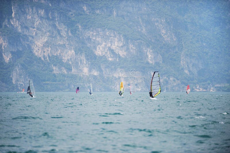 ITALIA, TORBOLE, LAGO GARDA, junio de 2018: Grupo de windsurfers encendido al norte del lago Garda imagen de archivo libre de regalías ITALIA, TORBOLE, LAGO GARDA, junio de 2018: Grupo de windsurfers encendido al norte del lago Garda imagen de archivo libre de regalías