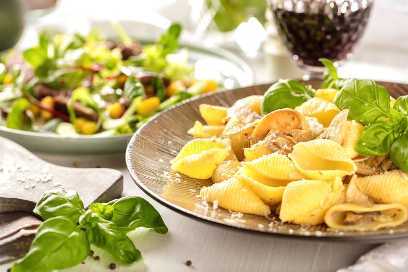 Italiaanse deegwaren in een romige saus met salade op een plaat, close-up royalty-vrije stock fotografie Italiaanse deegwaren in een romige saus met salade op een plaat, close-up royalty-vrije stock fotografie