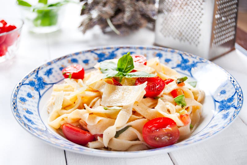 Italiaanse fettuccinedeegwaren met kersentomaten en parmezaanse kaas royalty-vrije stock foto Italiaanse fettuccinedeegwaren met kersentomaten en parmezaanse kaas royalty-vrije stock foto