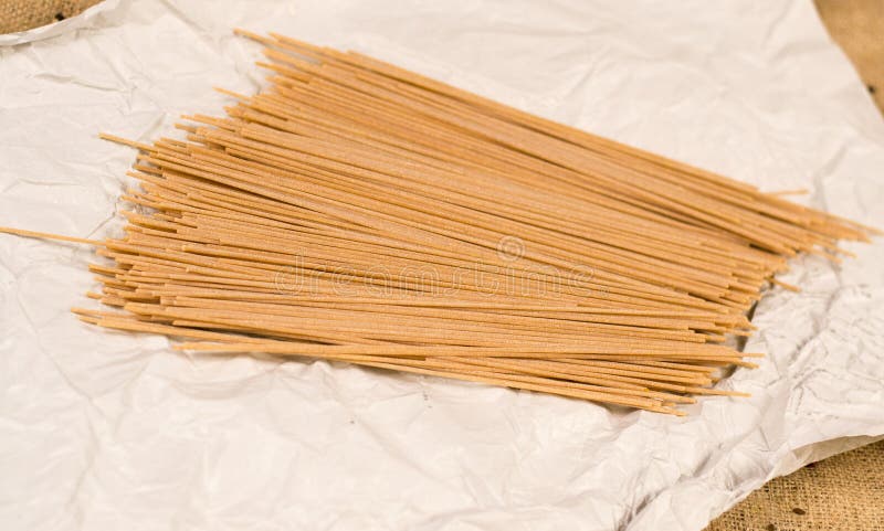 Italiaanse spaghettideegwaren op Witboek en canvas stock foto Italiaanse spaghettideegwaren op Witboek en canvas stock foto