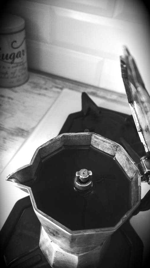 Italian aluminum small opened coffee pot full of black coffee on a kitchen stove top. Black and white stock images Italian aluminum small opened coffee pot full of black coffee on a kitchen stove top. Black and white stock images